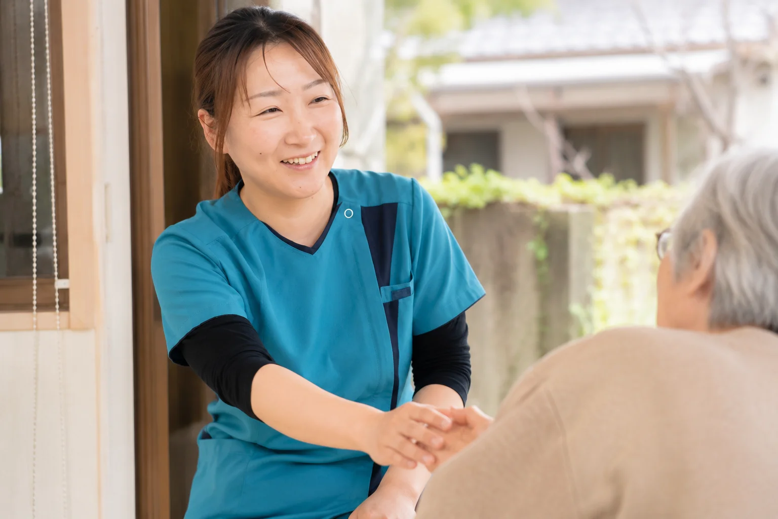 玄関で利用者さまを出迎えるスタッフ